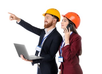 Engineer holding laptop while his colleague talking on smartphone against white background