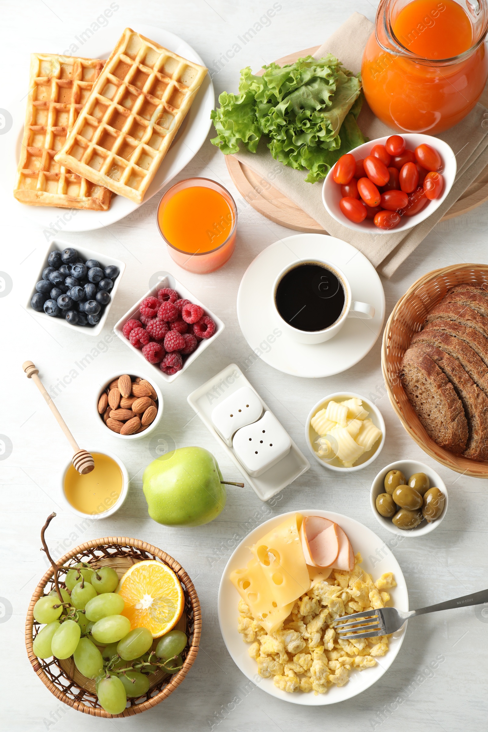 Photo of Tasty breakfast. Flat lay composition with many different food and drinks on light wooden table