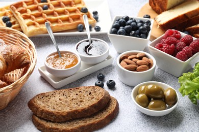 Photo of Tasty breakfast. Many different food on grey textured table, closeup