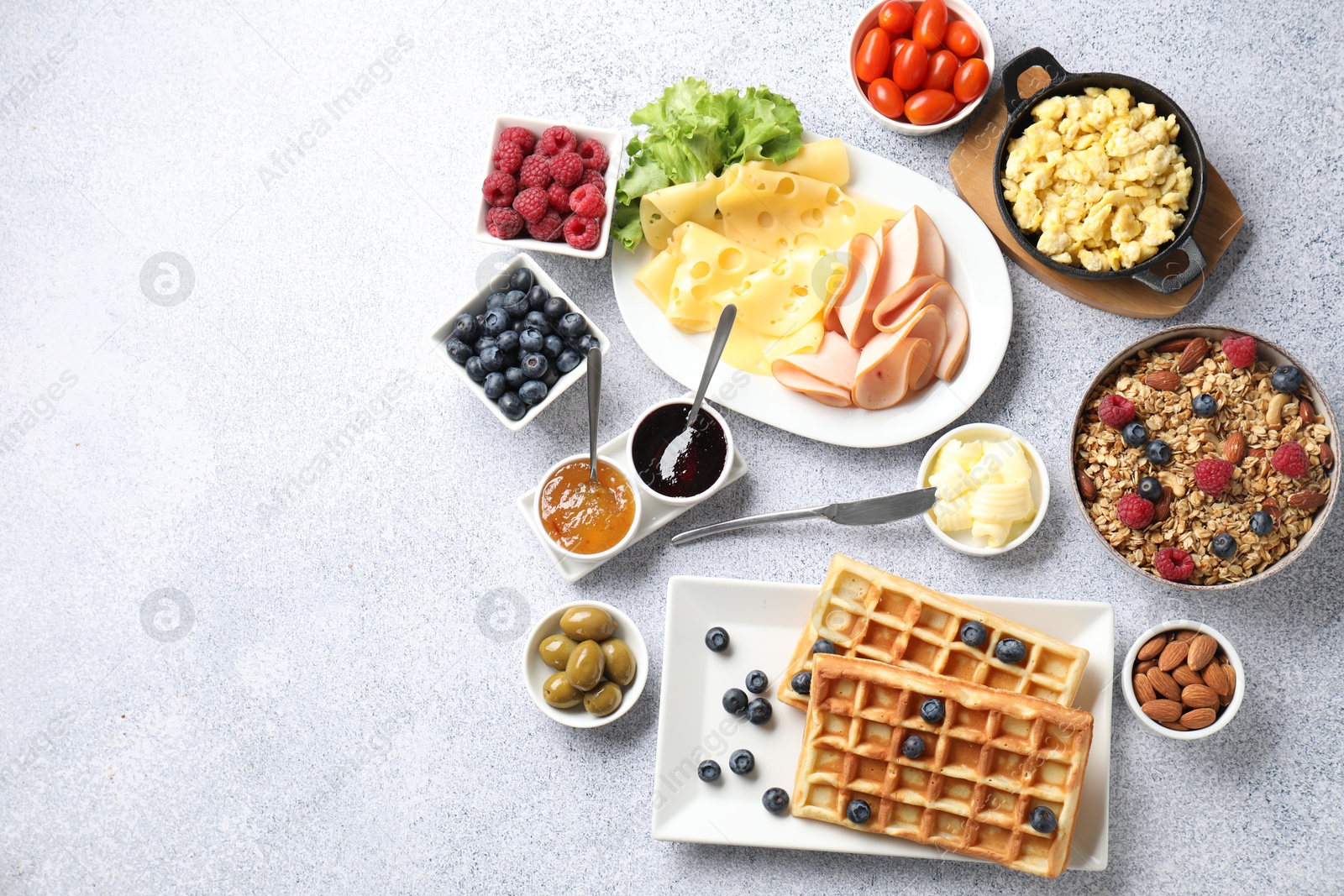 Photo of Tasty breakfast. Flat lay composition with many different food on grey textured table. Space for text