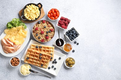 Photo of Tasty breakfast. Flat lay composition with many different food on grey textured table. Space for text