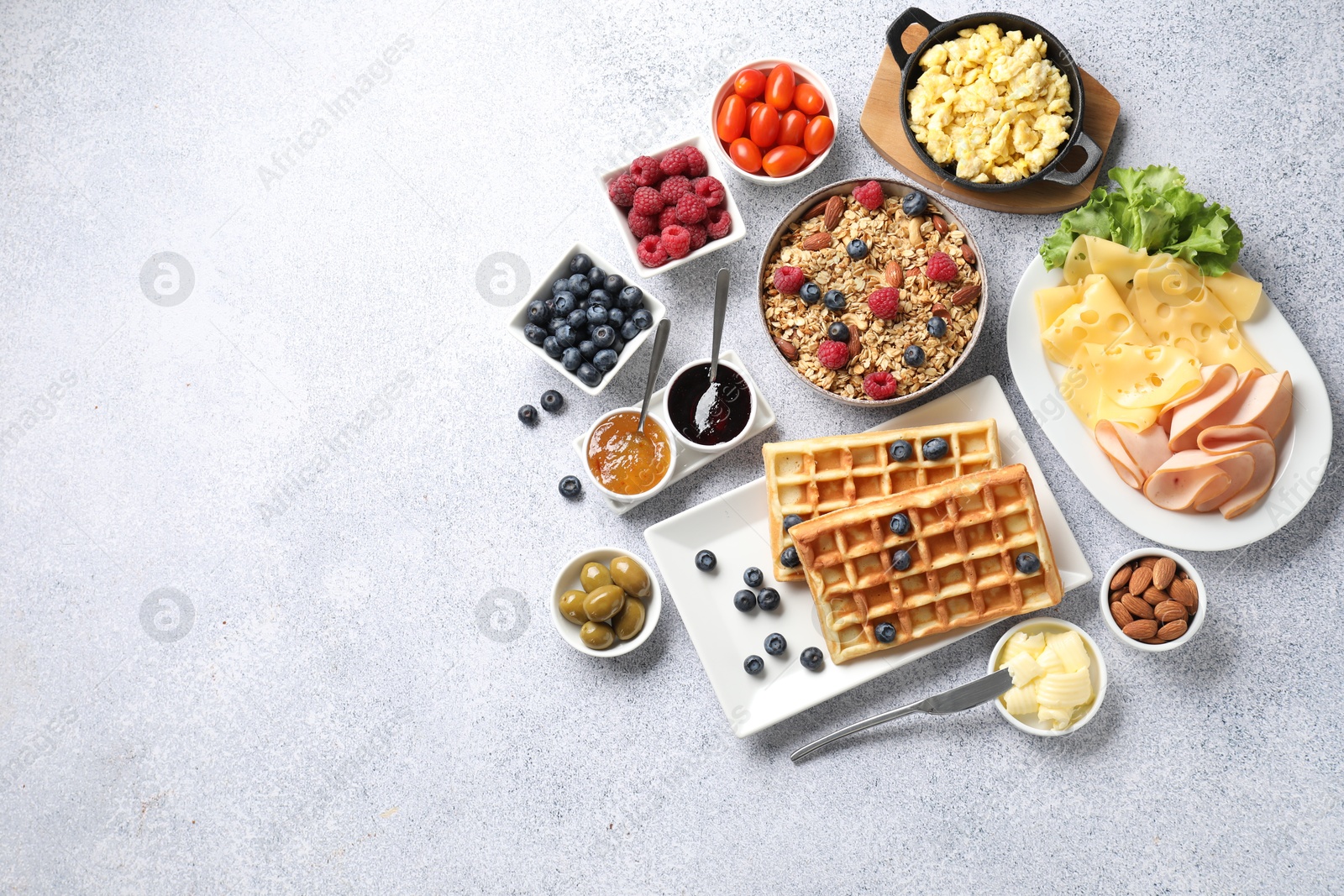 Photo of Tasty breakfast. Flat lay composition with many different food on grey textured table. Space for text