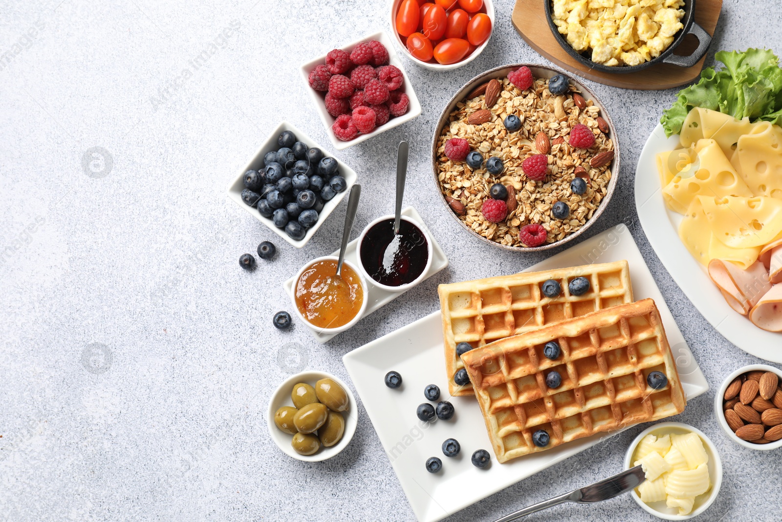 Photo of Tasty breakfast. Flat lay composition with many different food on grey textured table. Space for text