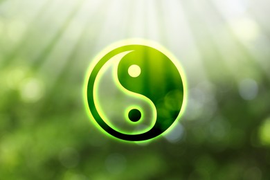 Image of Yin and yang symbol against blurred green trees