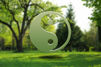 Image of Yin and yang symbol against blurred view of green park