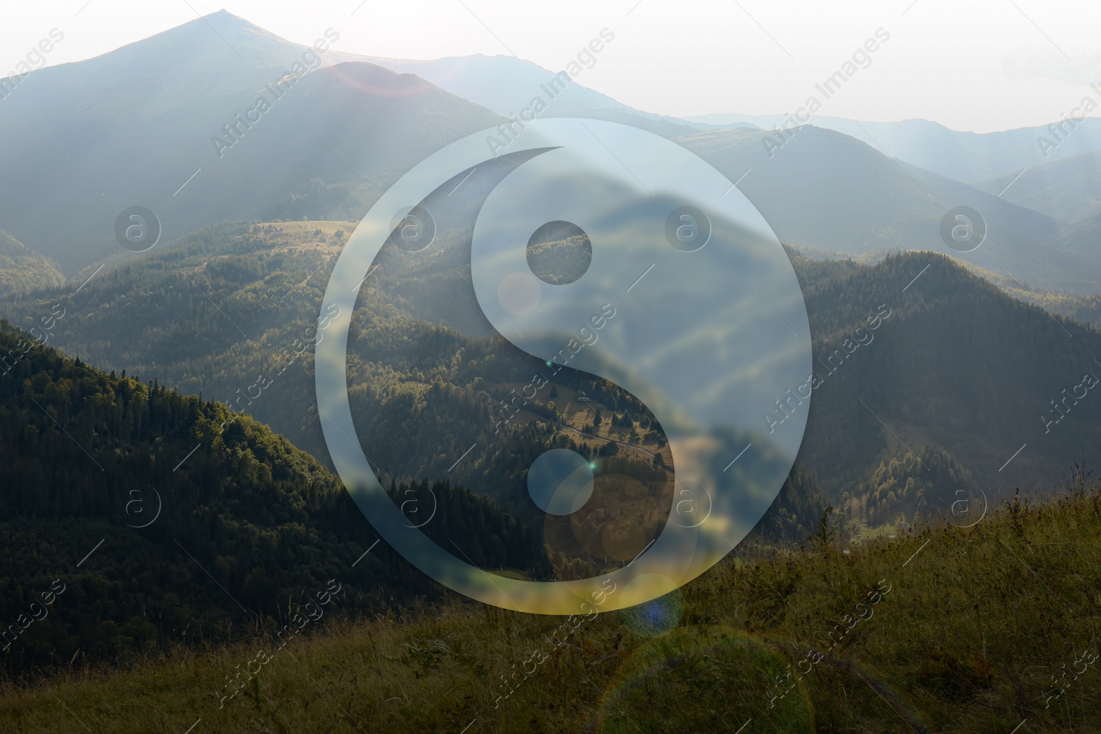 Image of Yin and yang symbol against picturesque mountain landscape