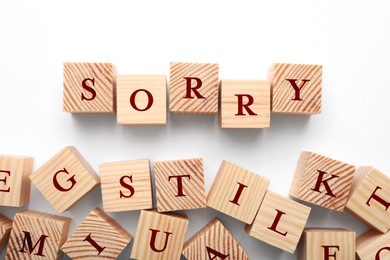 Image of Word Sorry of wooden cubes with letters on white table, top view