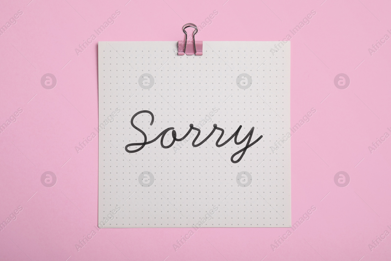 Image of Sorry paper note on pink background, top view