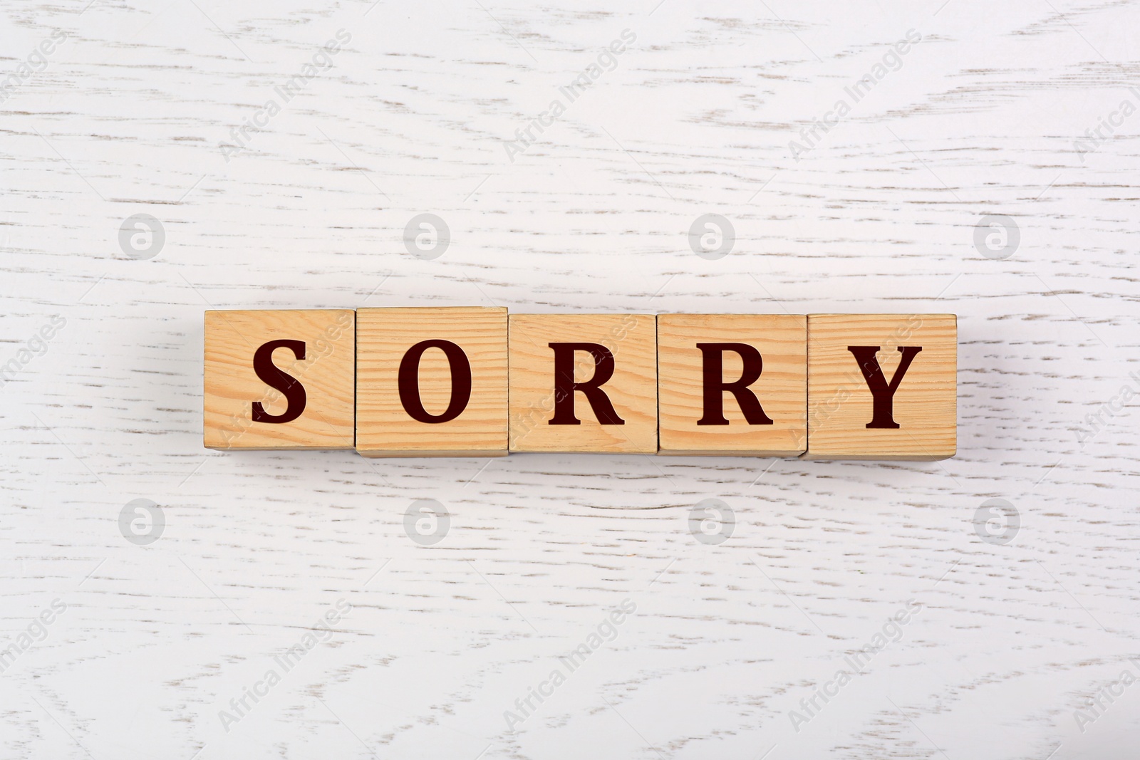 Image of Word Sorry of cubes with letters on white wooden table, top view