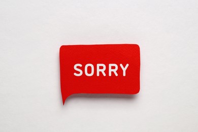 Image of Red paper speech balloon with word Sorry on light background