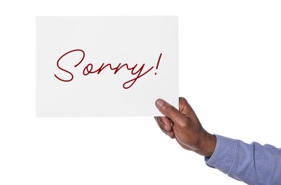 Image of Man holding sheet of paper with word Sorry on white background, closeup