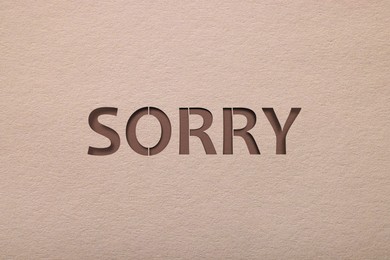 Word Sorry on beige background, apology card design