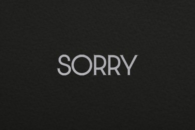 Word Sorry on black background, apology card design