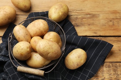 Many fresh potatoes on wooden table, flat lay