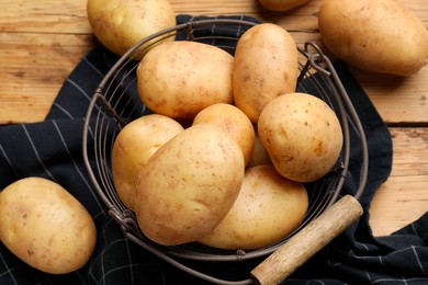 Photo of Many fresh potatoes on wooden table, flat lay