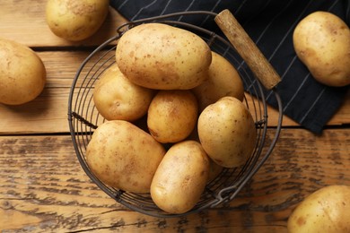 Photo of Many fresh potatoes on wooden table, flat lay