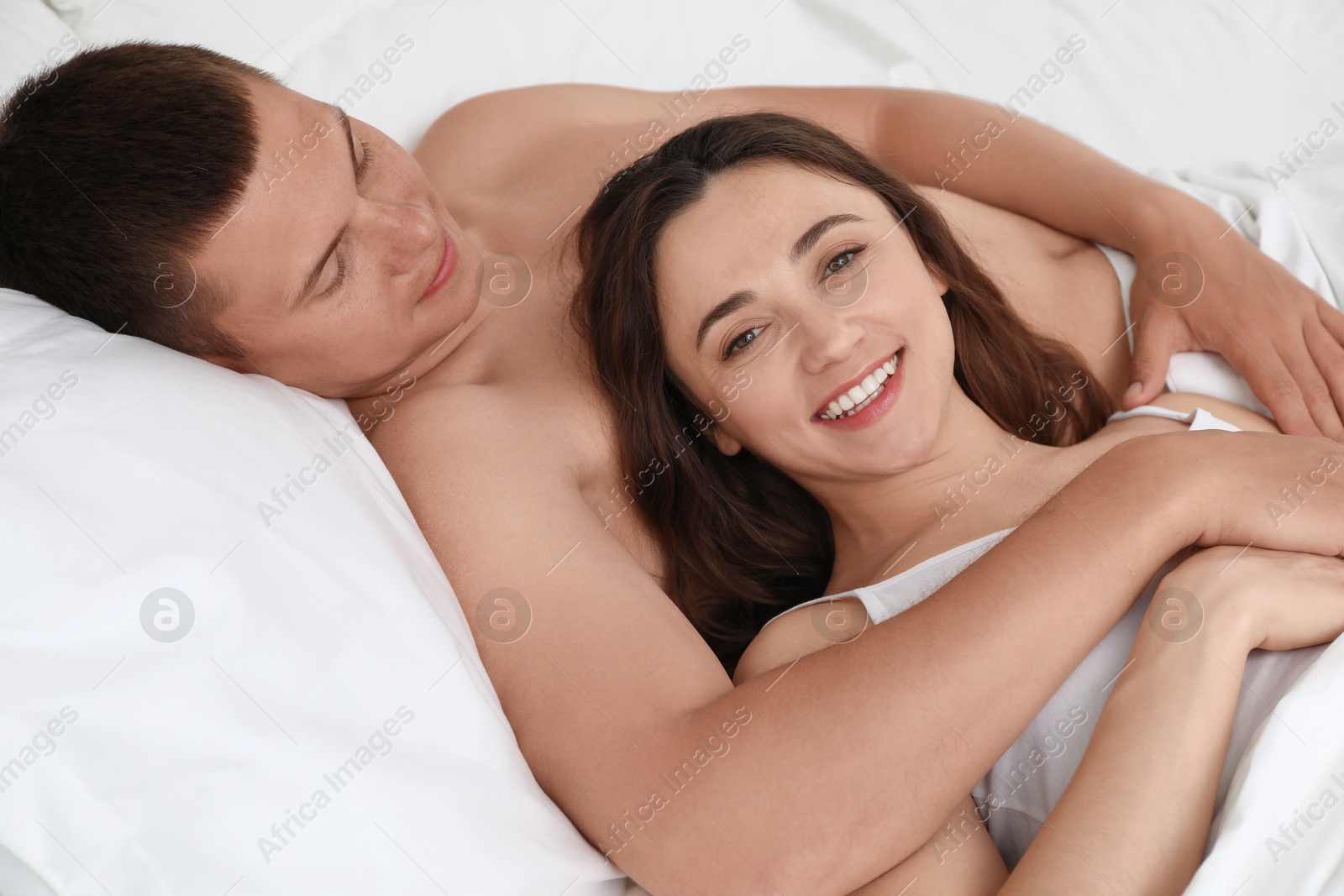 Photo of Happy couple lying in bed at home