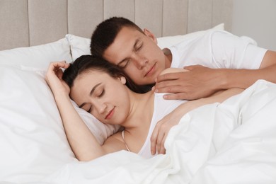 Lovely couple sleeping together in bed at home