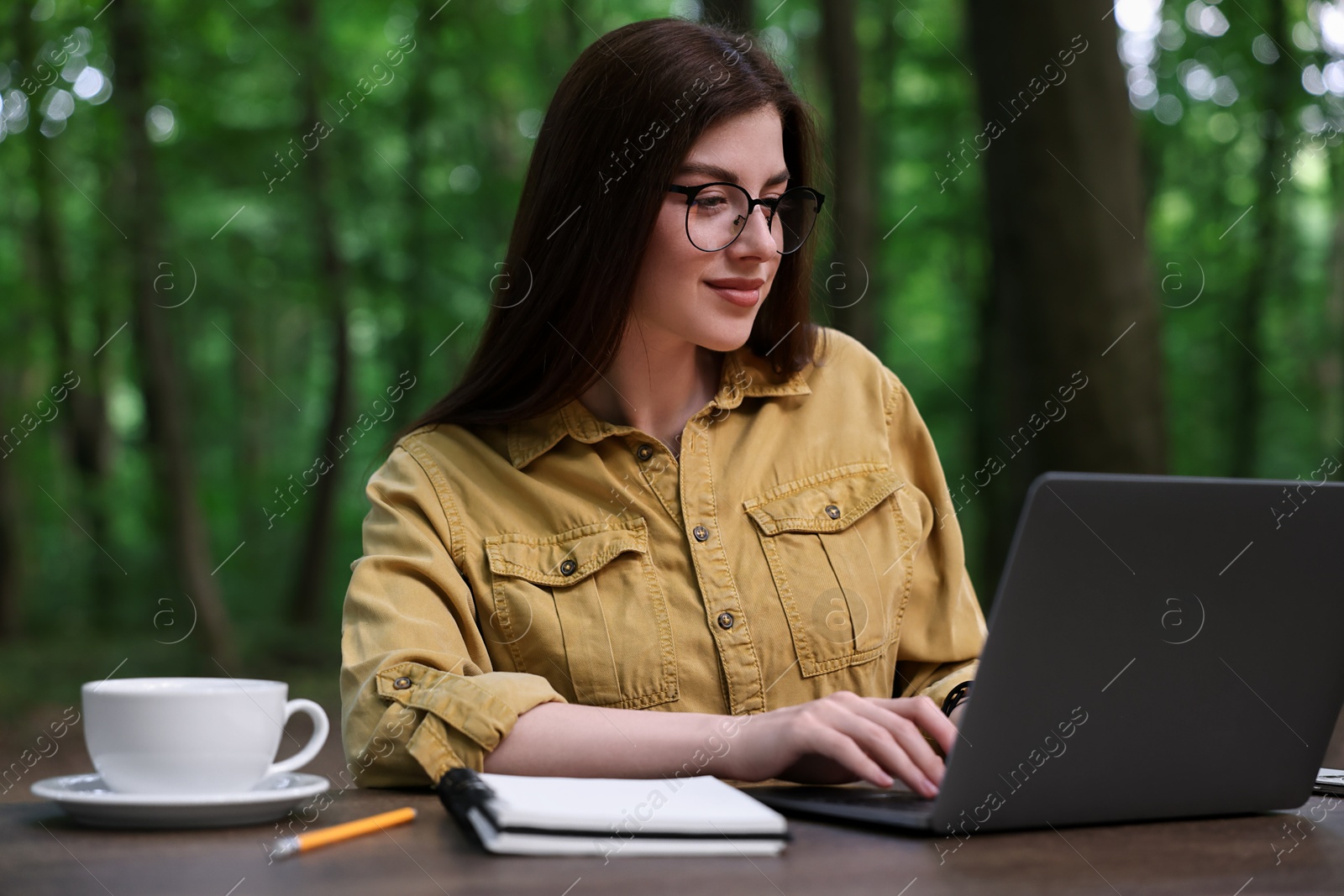 Photo of Freelancer working with laptop at table outdoors. Remote job