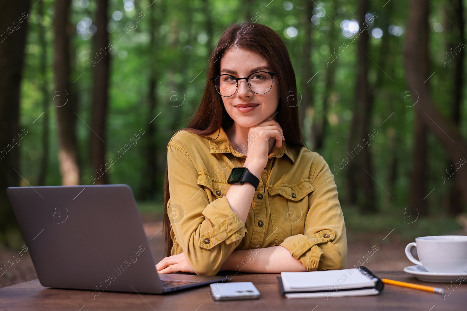 Photo of Freelancer working with laptop at table outdoors. Remote job