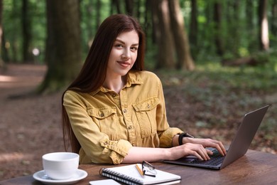 Freelancer working with laptop at table outdoors. Remote job