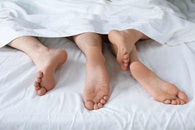 Lovely couple lying in bed at home, closeup view