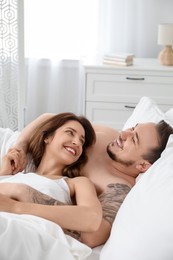 Lovely couple enjoying time together in bed at morning