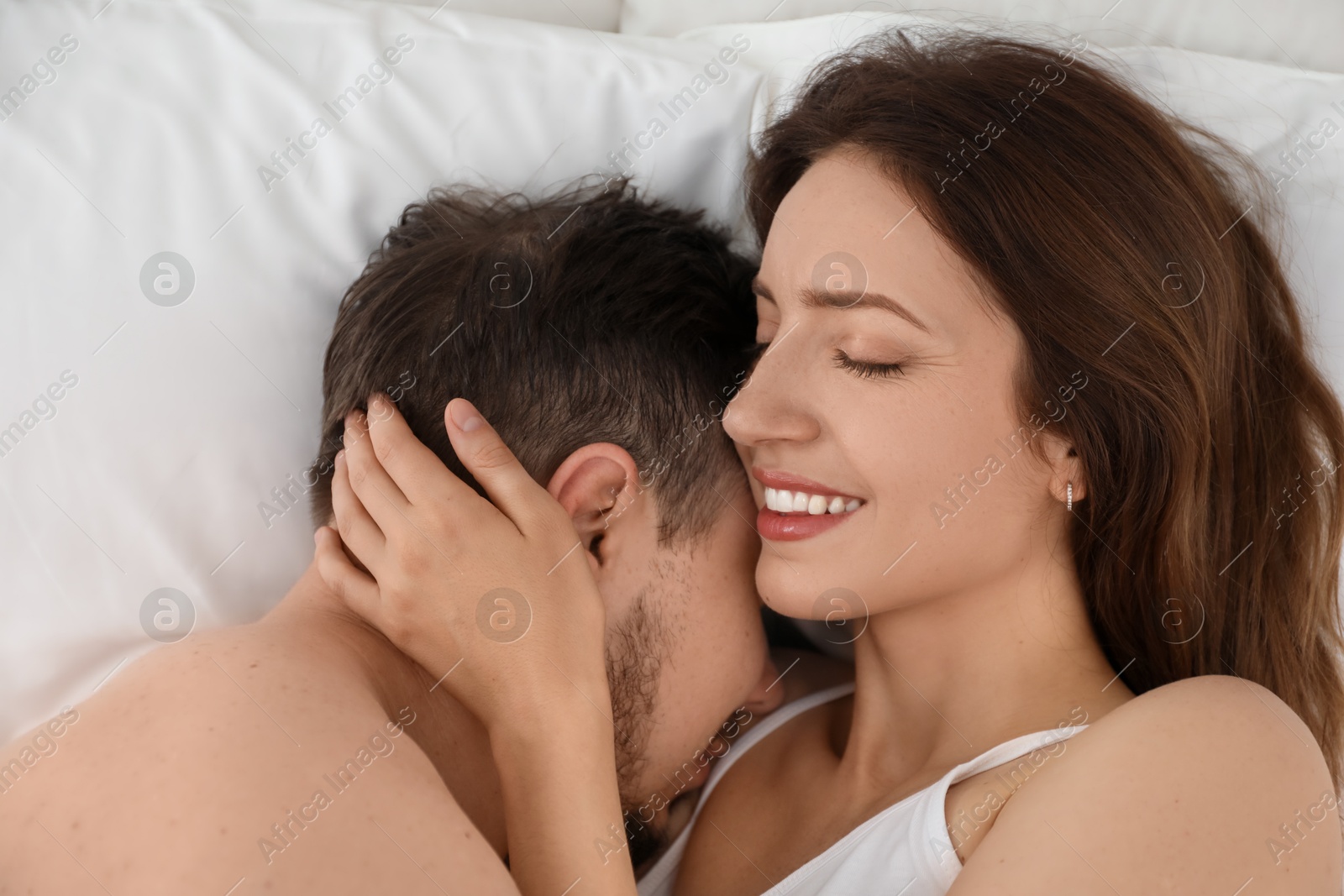 Photo of Lovely couple enjoying time together in bed at morning, top view