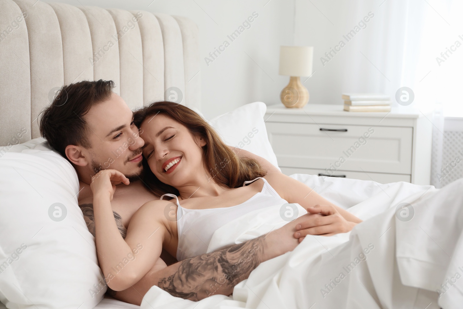 Photo of Lovely couple enjoying time together in bed at morning