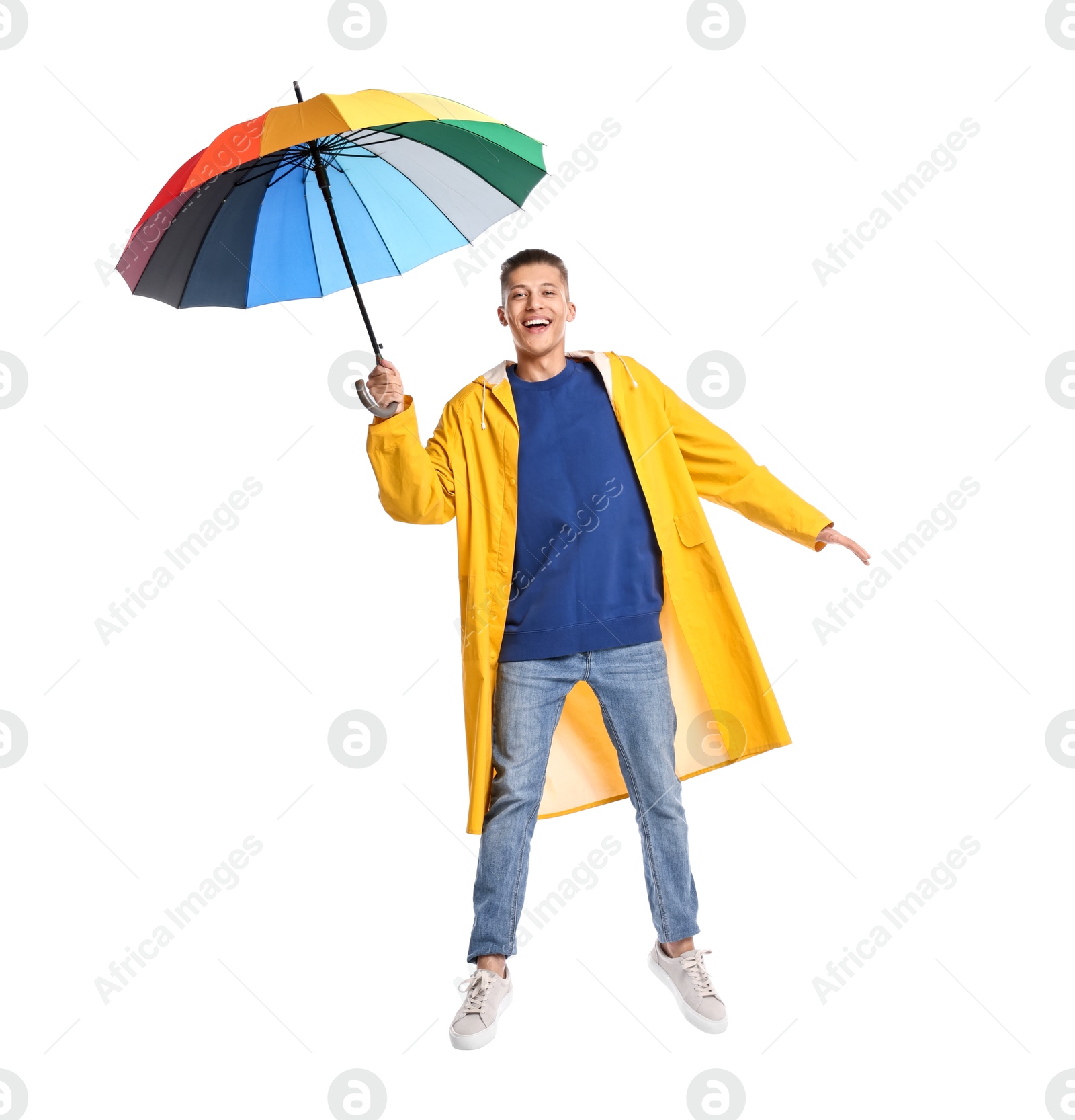 Photo of Young man with rainbow umbrella jumping on white background