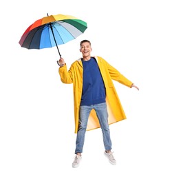 Young man with rainbow umbrella jumping on white background