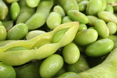 Photo of Raw green edamame soybeans and pods as background, closeup