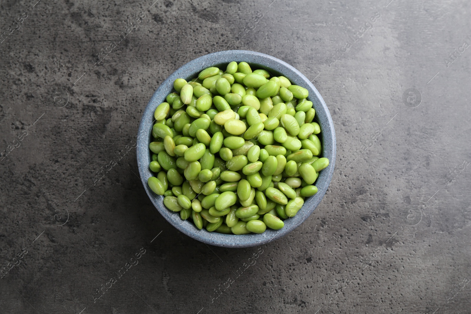 Photo of Raw green edamame soybeans on grey table, top view