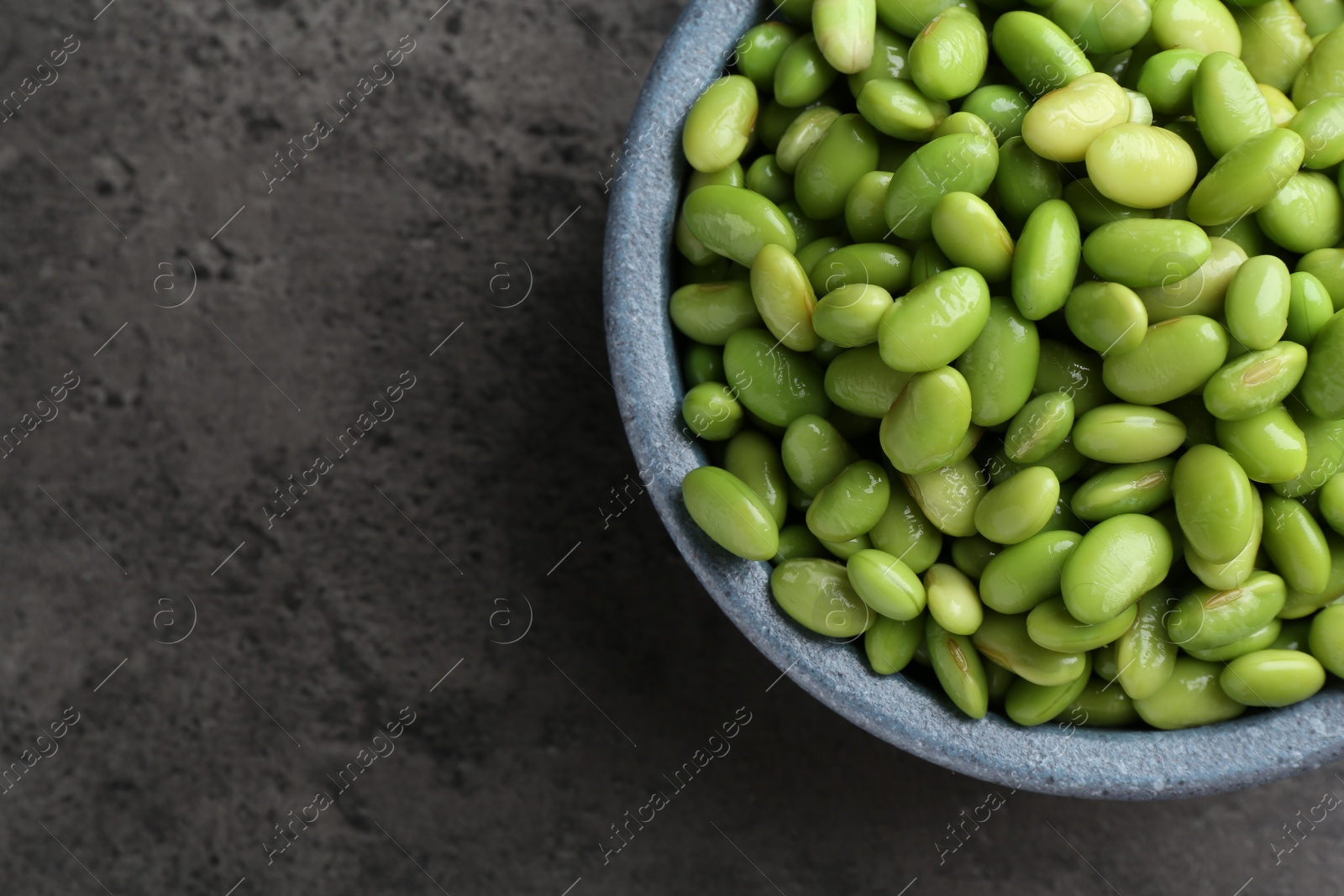 Photo of Raw green edamame soybeans on grey table, top view. Space for text