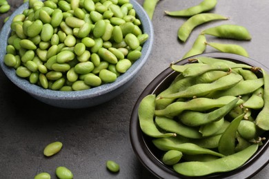 Photo of Raw green edamame soybeans and pods on grey table, closeup