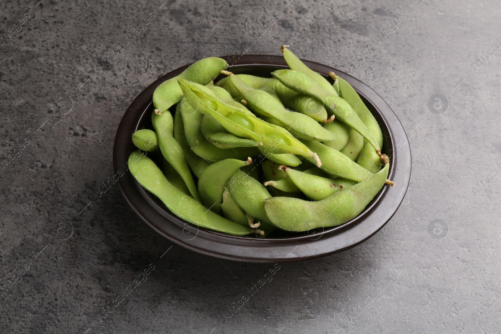 Photo of Raw green edamame pods on grey table