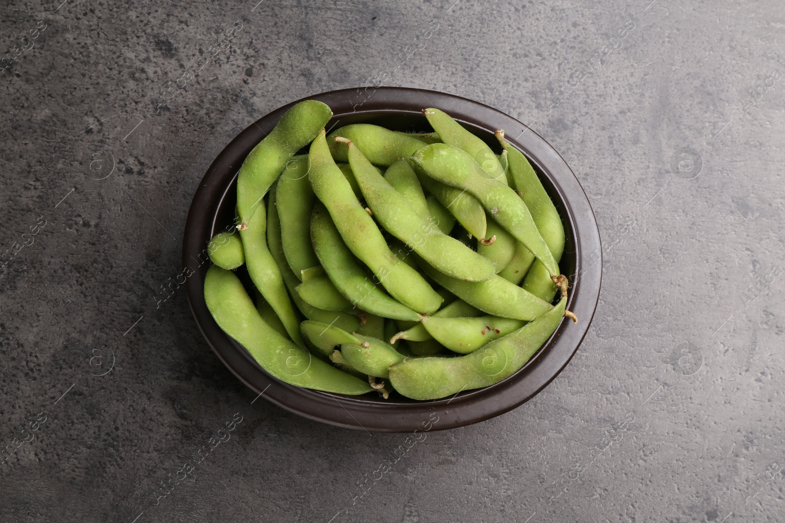 Photo of Raw green edamame pods on grey table, top view