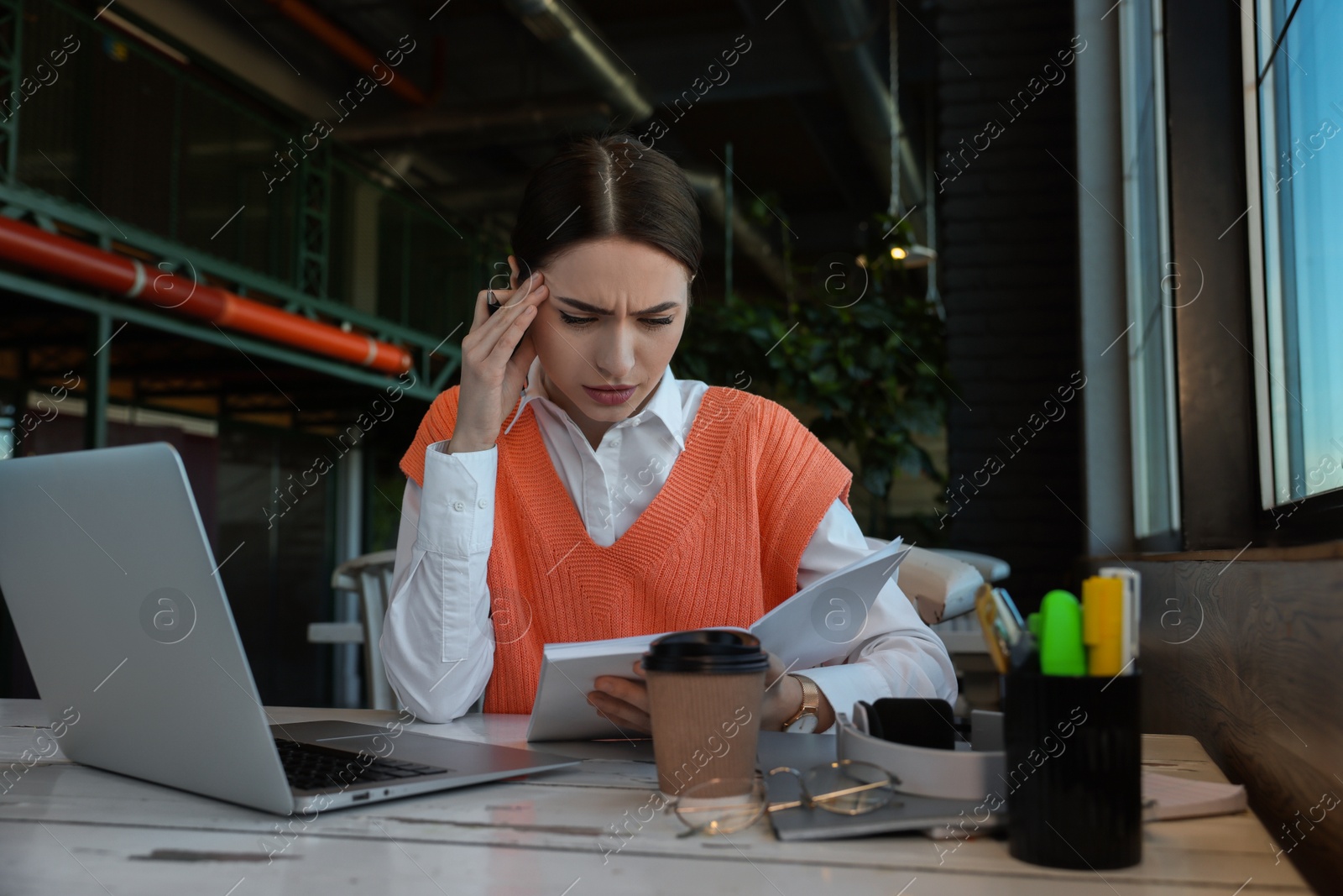 Photo of Young female student with laptop studying at table in cafe