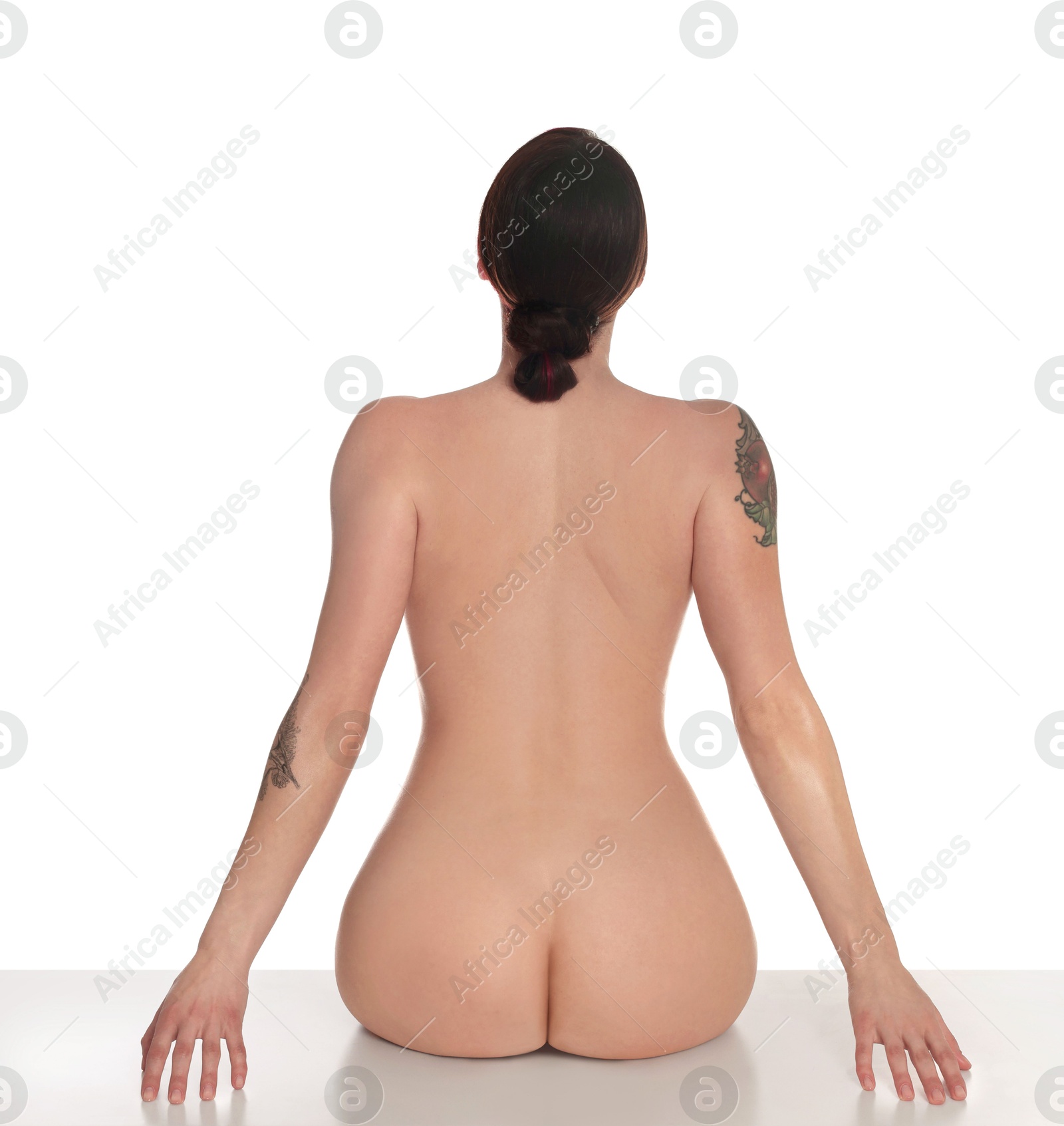 Photo of Nude woman posing on white background, back view