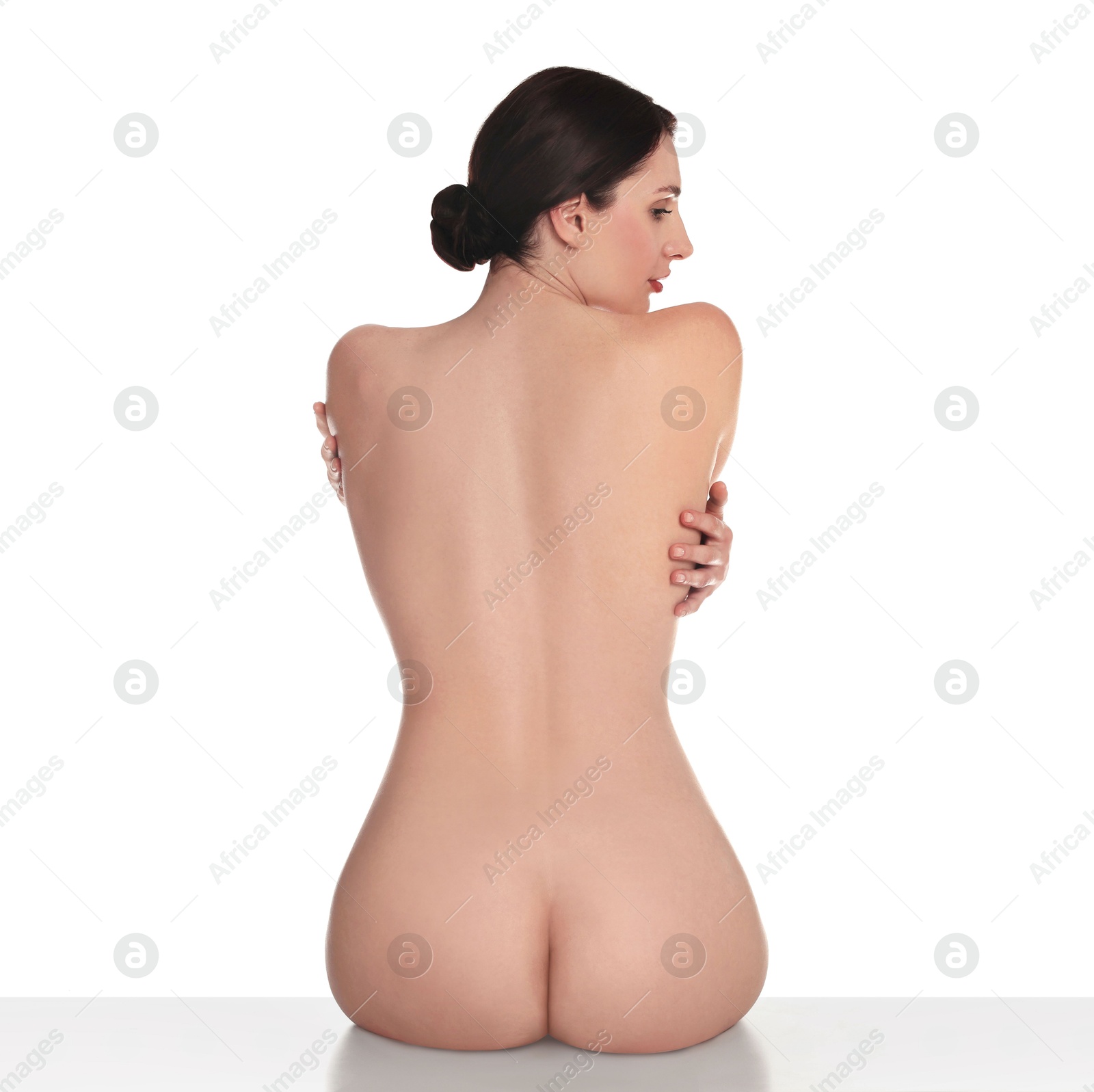 Photo of Nude woman posing on white background, back view