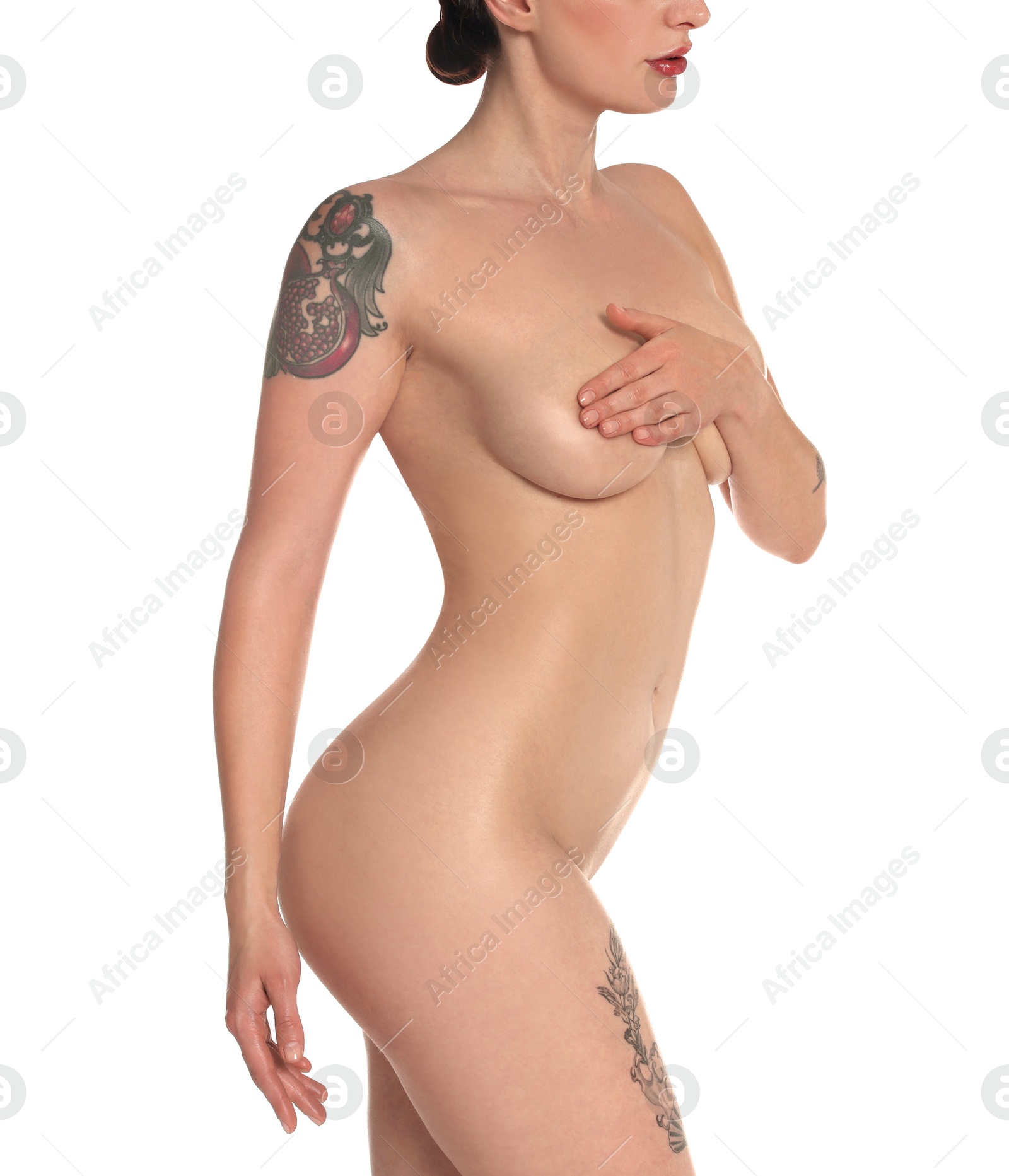 Photo of Nude woman with tattoos posing on white background, closeup