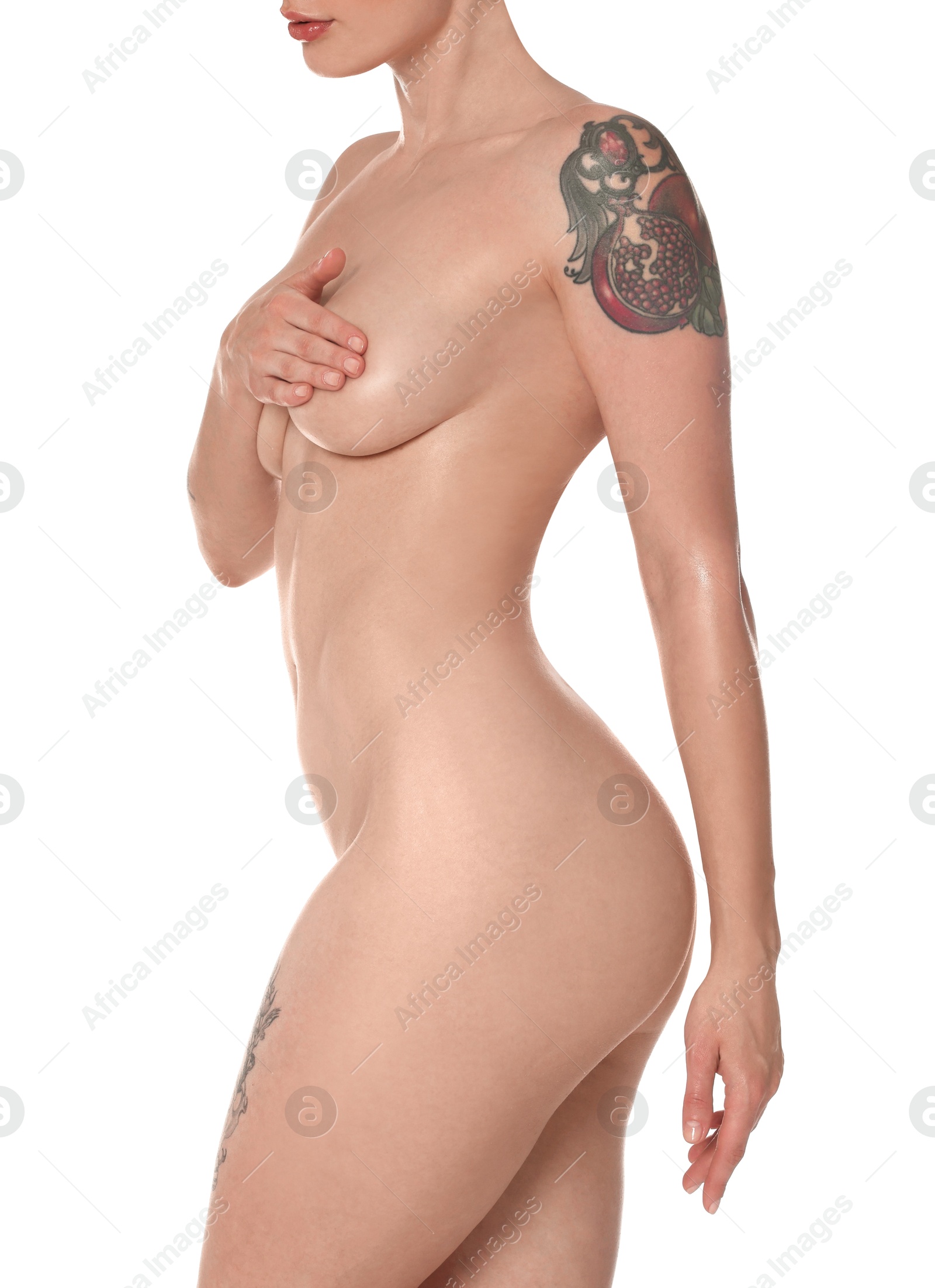 Photo of Nude woman with tattoos posing on white background, closeup