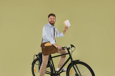 Postman on bicycle delivering letters against light green background