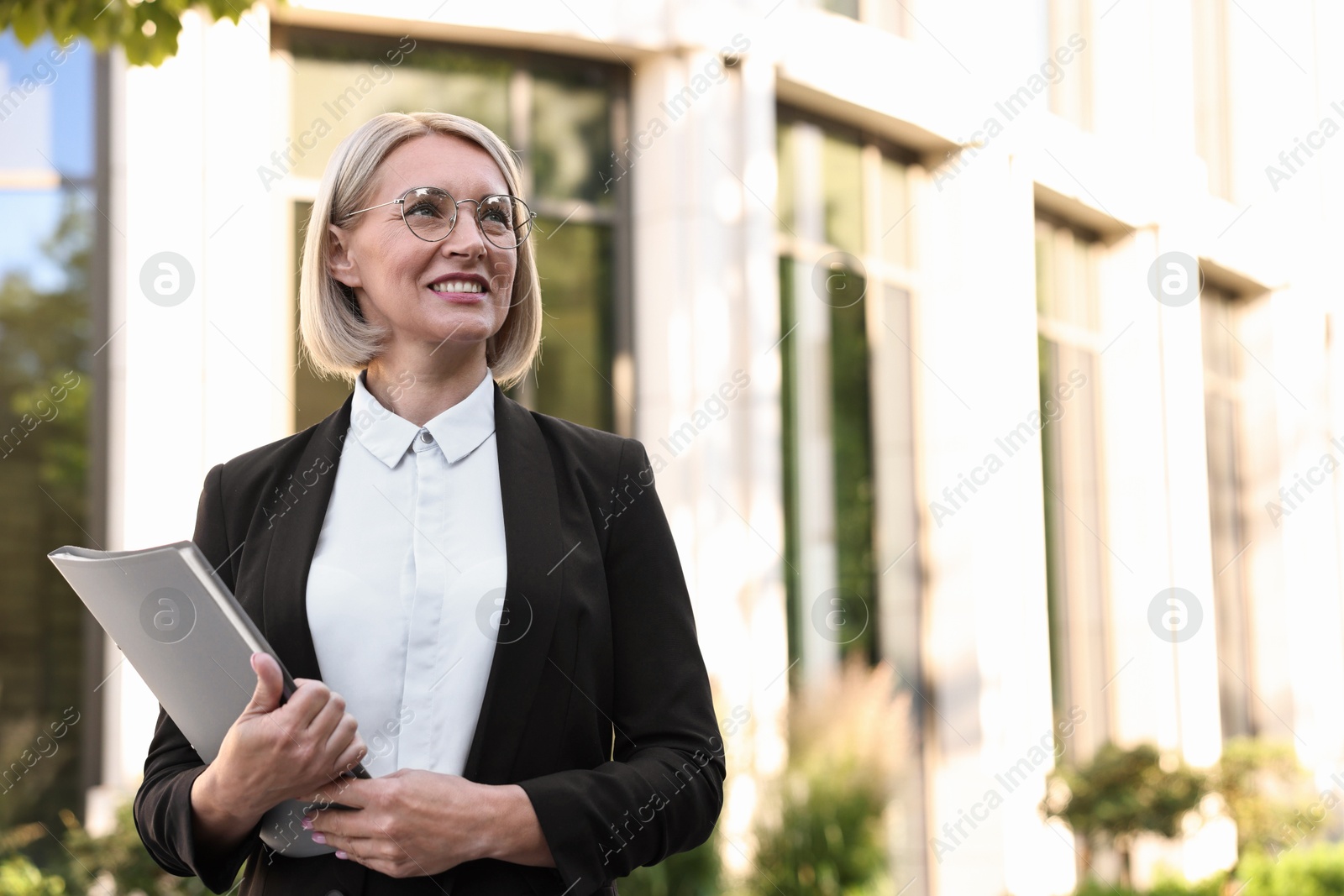 Photo of International relations. Diplomat with clipboard outdoors, space for text