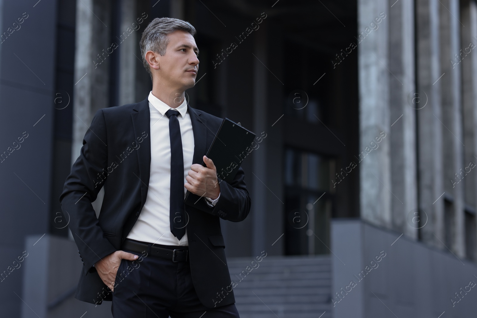 Photo of International relations. Diplomat with clipboard in suit outdoors, space for text