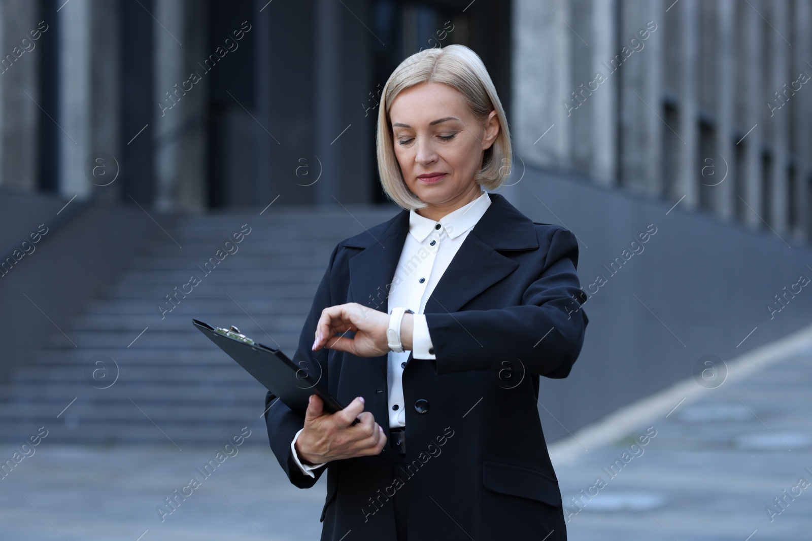 Photo of International relations. Diplomat with clipboard in suit outdoors