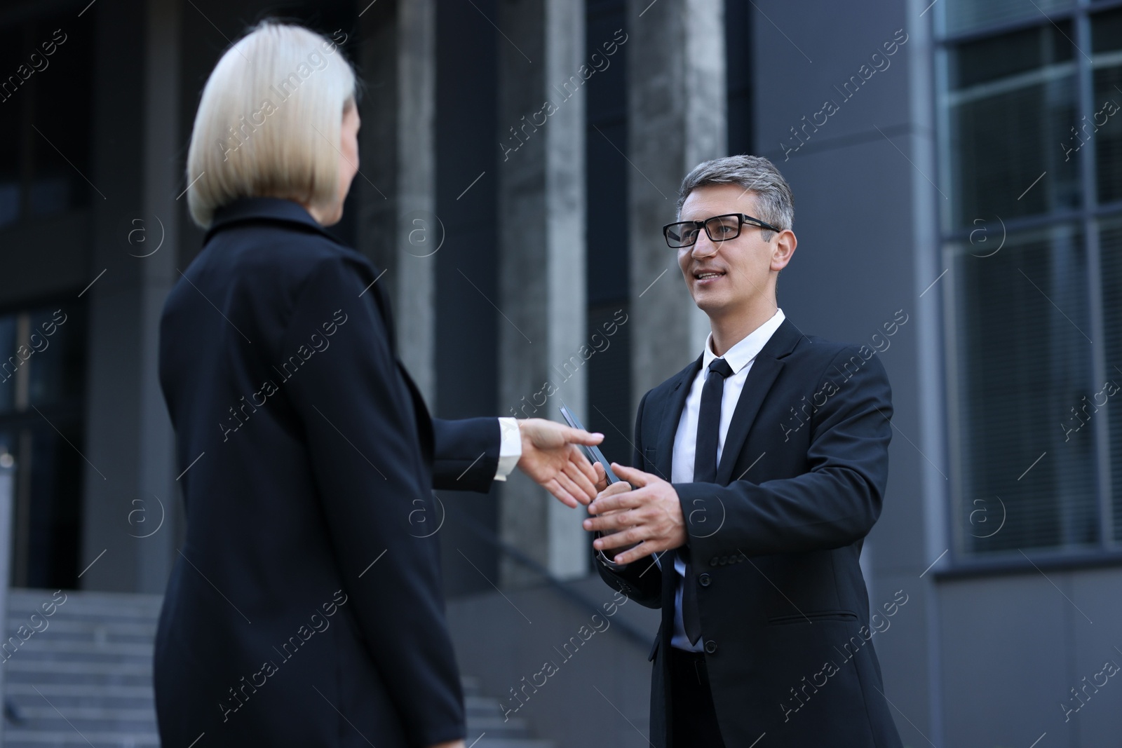 Photo of International relations. Diplomats shaking hands during meeting outdoors