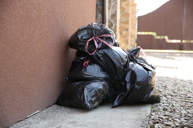 Photo of Many trash bags full of garbage outdoors