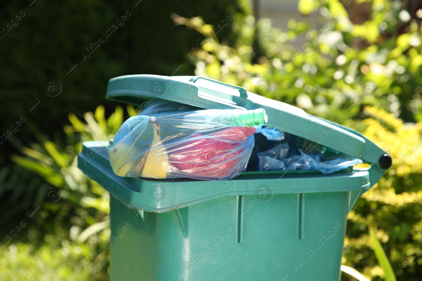 Photo of Trash bags in garbage bin outdoors, closeup