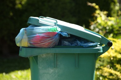 Photo of Trash bags in garbage bin outdoors, closeup
